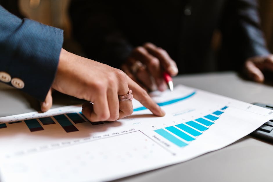 Close-up of hands analyzing financial charts during a business meeting.